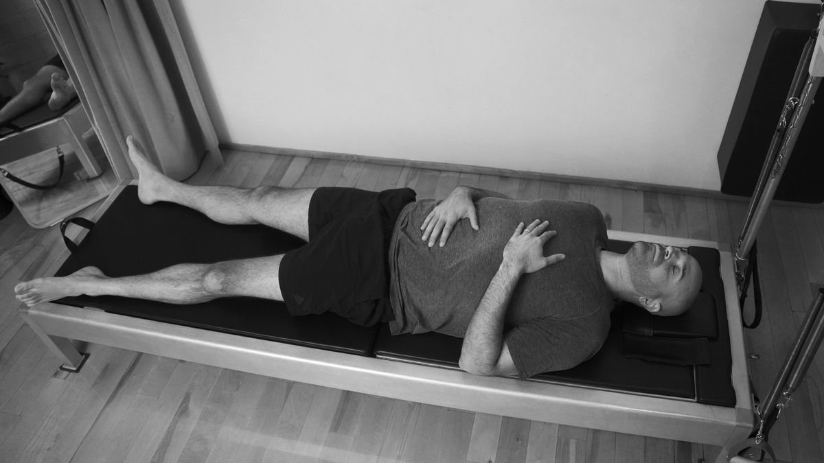 A serene man in a meditative pose following a Pilates session, embodying the calming and mental health benefits of the practice.