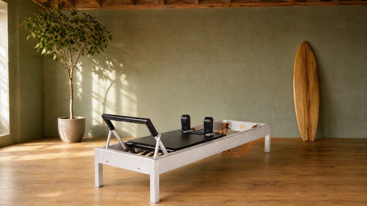 Private one-on-one Pilates reformer in a West Hollywood studio with a vintage surfboard resting against the wall