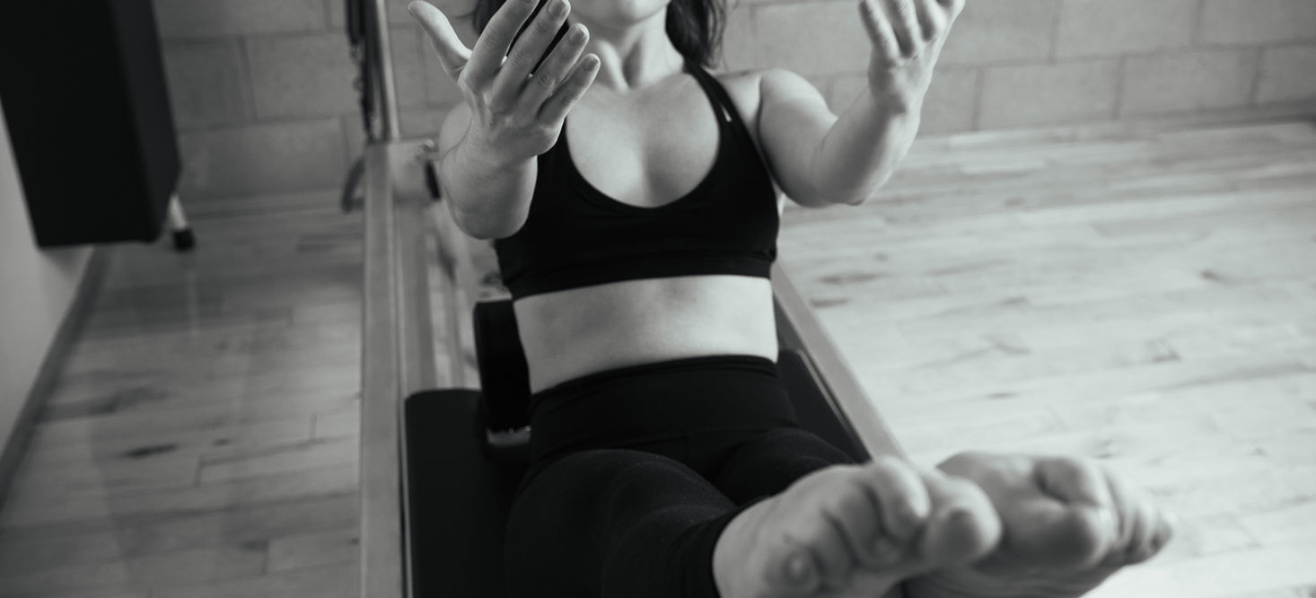 A client working through a mat sequence during a virtual Pilates session
